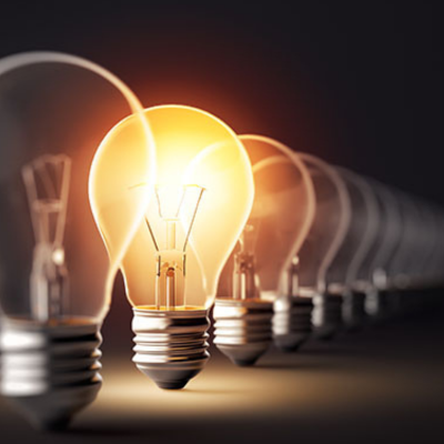 Row of light bulbs with one illuminated in the foreground, symbolizing innovation and bright ideas.